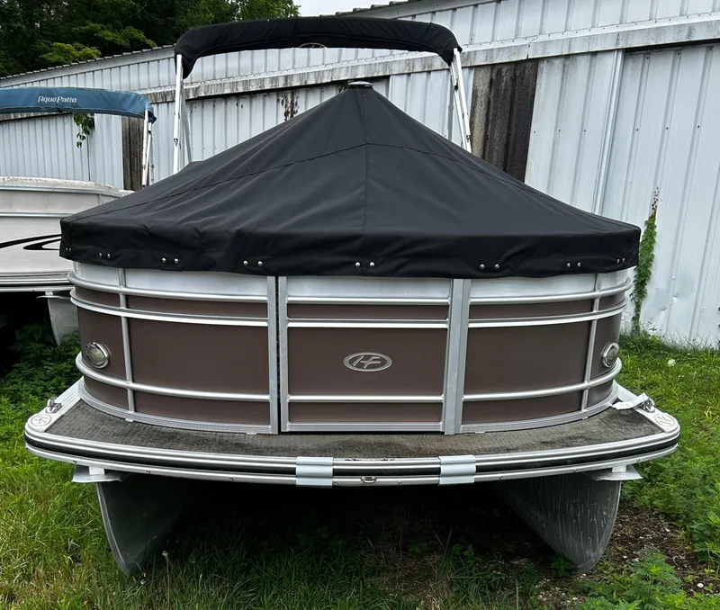 Slide: The Image of 2015 Harris Sunliner 220 pontoon boat with black cover, parked on grass. - 2