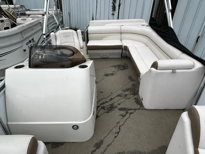 Slide: The Image of 2015 Harris Sunliner 220 pontoon boat interior with white seating and steering console. - 3