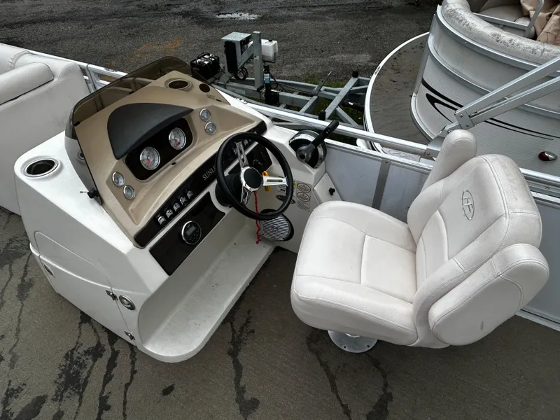 Slide: The Image of 2015 Harris Sunliner 220 boat console with steering wheel and white captain's chair. - 5
