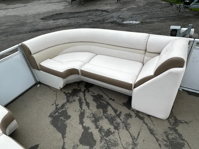 Slide: The Image of 2015 Harris Sunliner 220 boat interior with white and brown seating on a textured floor. - 8