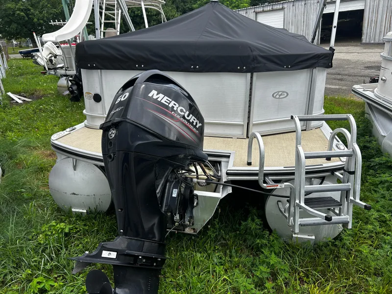 Slide: The Image of 2015 Harris Sunliner 220 pontoon boat with Mercury 60 outboard motor, parked on grass. - 9