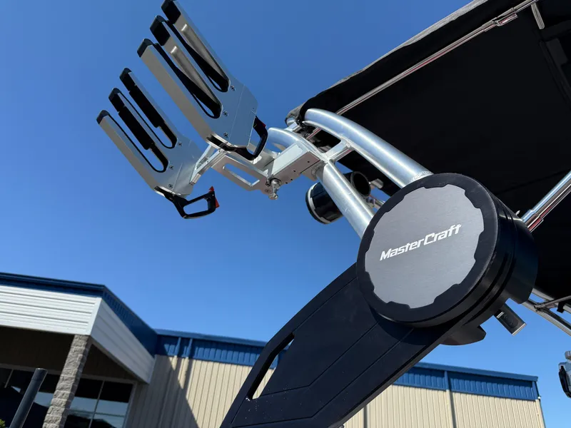 Slide: The Image of 2025 MasterCraft NXT22 boat tower with wakeboard rack against blue sky. - 10