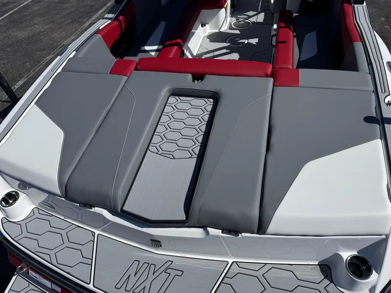 Slide: The Image of 2025 MasterCraft NXT22 boat interior with red and gray seating, hexagonal pattern design. - 14