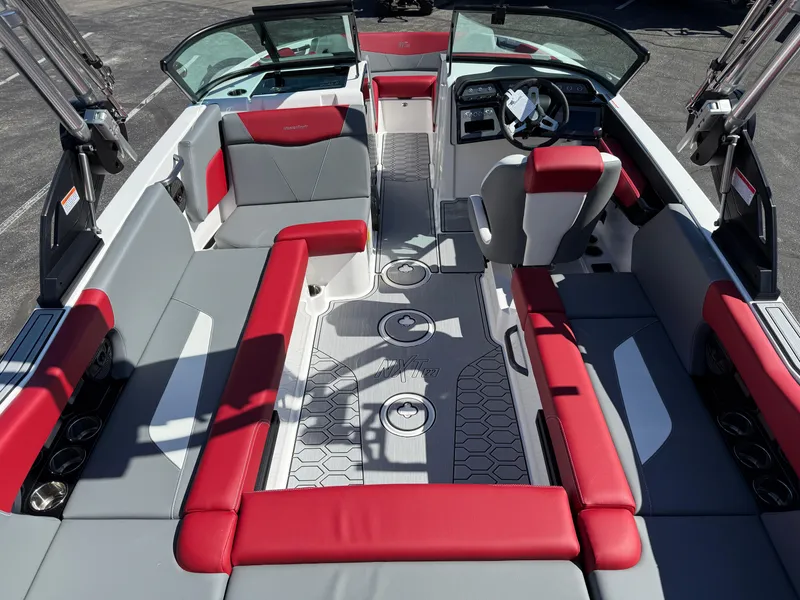 Slide: The Image of 2025 MasterCraft NXT22 boat interior with red and gray seating, modern dashboard, and open layout. - 15