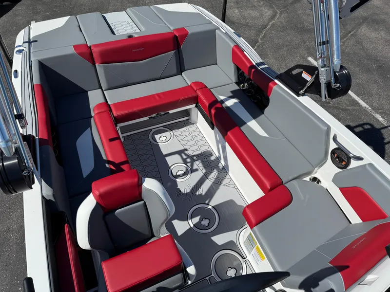 Slide: The Image of 2025 MasterCraft NXT22 boat interior with red and gray seating, hexagonal floor pattern. - 17