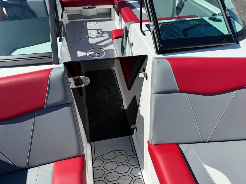 Slide: The Image of 2025 MasterCraft NXT22 boat interior with red and gray seating, open windshield, and hexagonal flooring. - 18