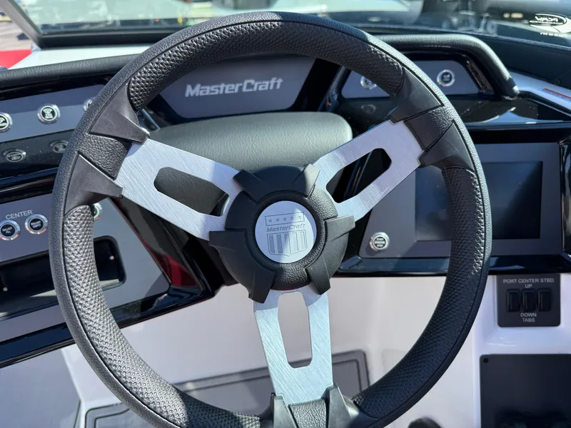 Slide: The Image of Steering wheel of 2025 MasterCraft NXT22 boat, featuring modern dashboard controls. - 21