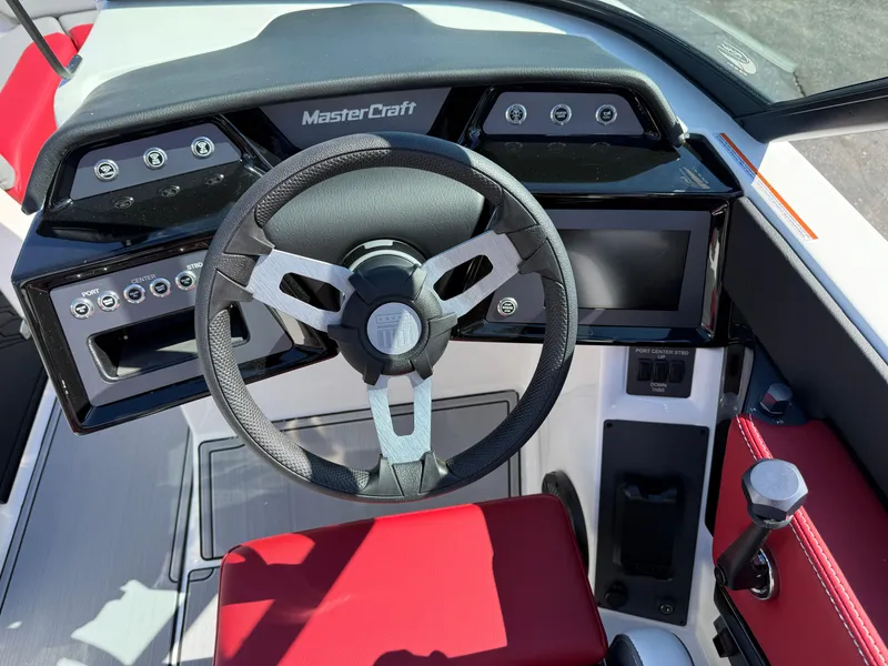 Slide: The Image of 2025 MasterCraft NXT22 boat dashboard with steering wheel and control panel. - 22