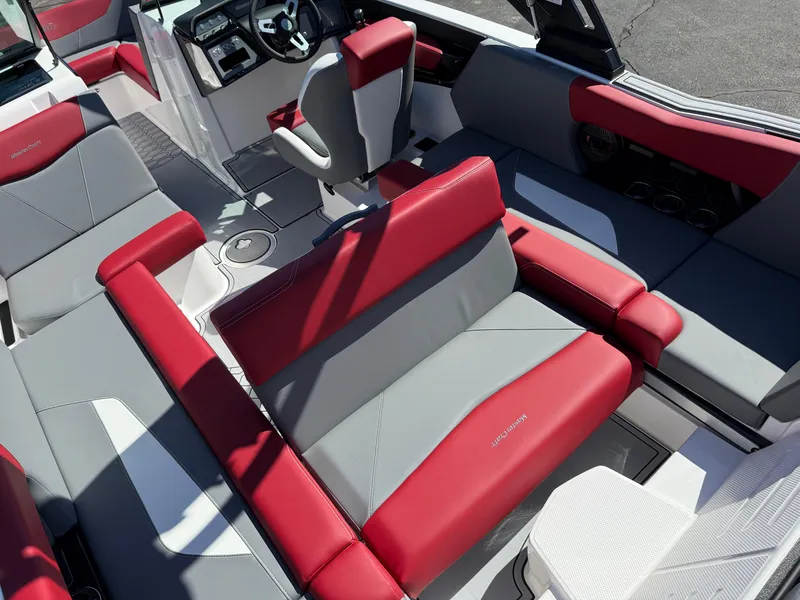 Slide: The Image of 2025 MasterCraft NXT22 boat interior with red and gray seating, modern dashboard, and steering wheel. - 31