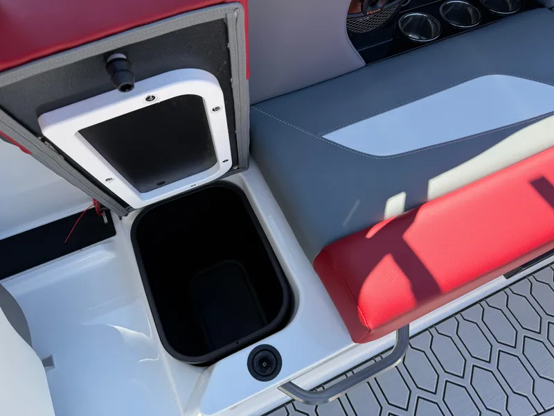 Slide: The Image of 2025 MasterCraft NXT22 boat interior storage compartment with red and gray seating. - 32