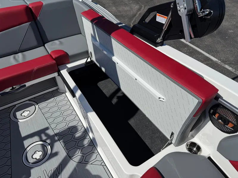 Slide: The Image of 2025 MasterCraft NXT22 boat interior with open storage compartment, red and gray seating. - 45