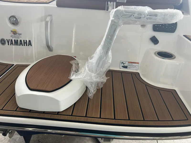 Slide: The Image of 2024 Yamaha Boats 222 S deck with wood finish and wrapped accessory. - 3