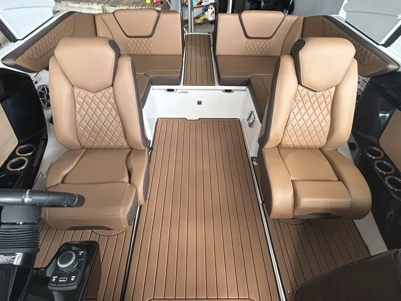 Slide: The Image of 2024 Yamaha Boats 222 S interior with tan leather seats and wood-style flooring. - 4