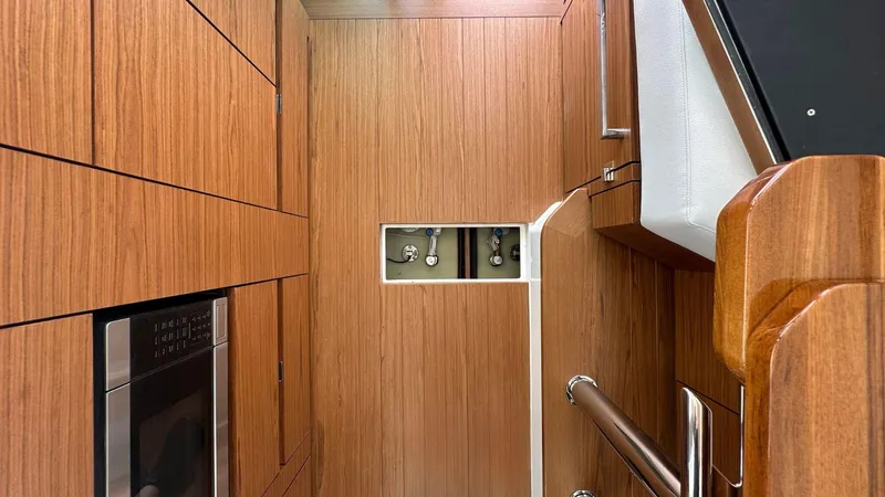 Slide: The Image of Interior of 2026 Tiara Yachts 43 LE, featuring sleek wood paneling and modern appliances. - 26