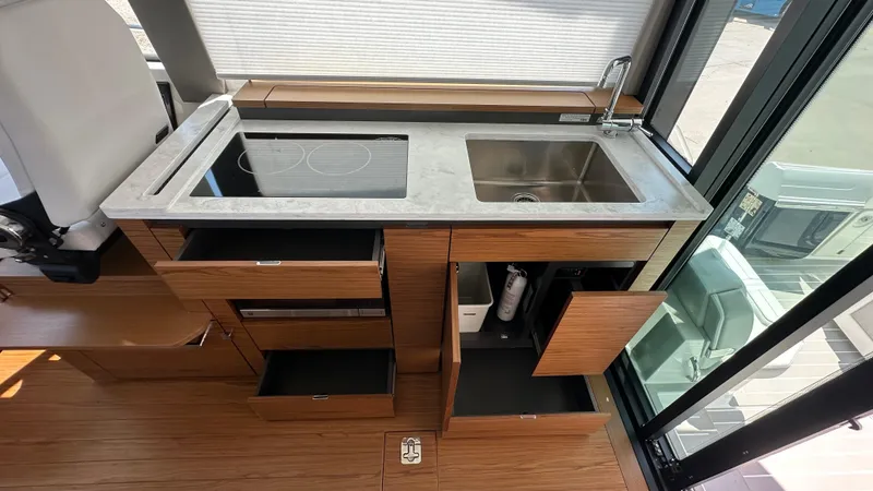 Slide: The Image of Modern kitchen area in 2026 Tiara Yachts 43 LE, featuring stove, sink, and wooden cabinetry. - 28