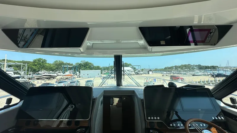 Slide: The Image of Interior view of 2026 Tiara Yachts 43 LE helm with dual screens and marina backdrop. - 36