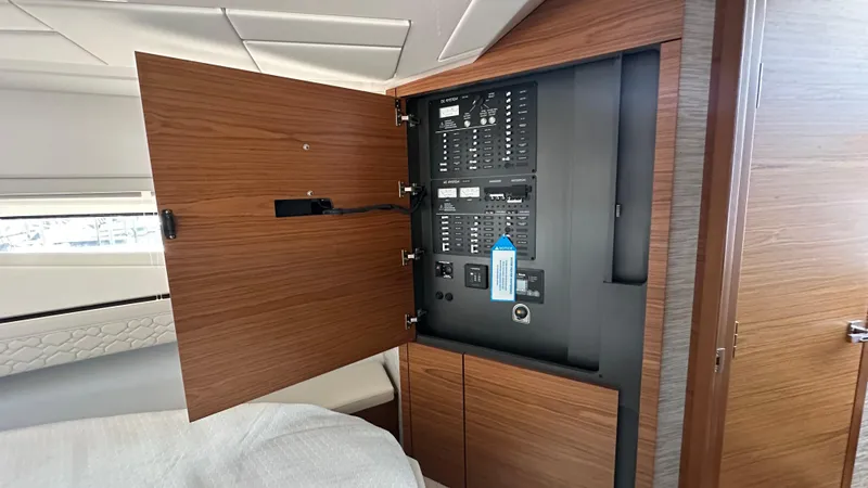 Slide: The Image of Electrical panel inside 2026 Tiara Yachts 43 LE, featuring wooden cabinetry and modern design. - 43