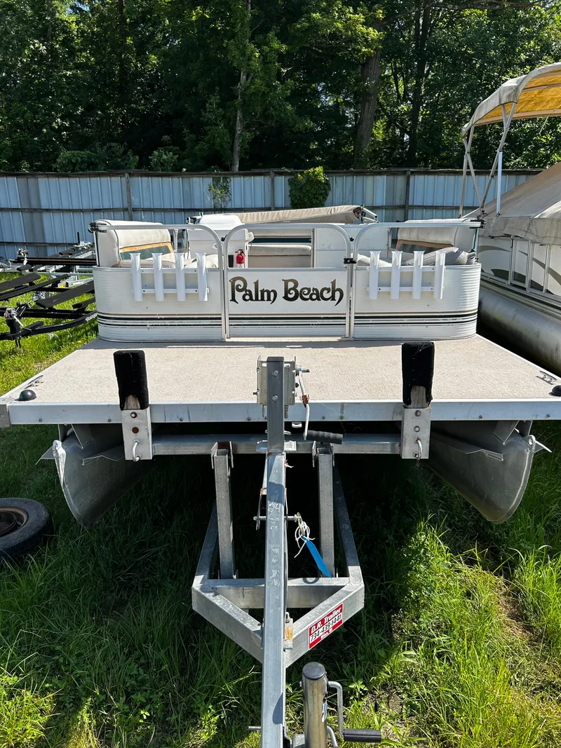 Slide: The Image of 2007 Palm Beach Sport Cruise 2423 pontoon boat on trailer, parked on grass. - 10