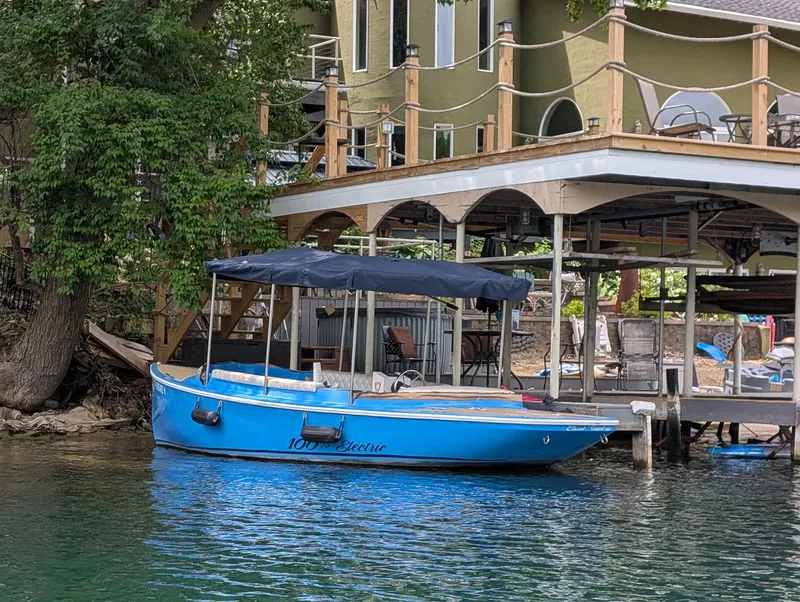 The Image of 2019 Vision Marine Technologies Fantail 217 electric boat docked by a lakeside house. - 0