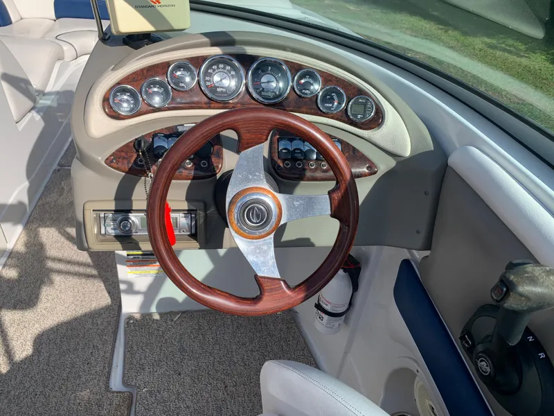 Slide: The Image of 2012 Crownline Eclipse E4 boat dashboard with wood-trimmed steering wheel and instrument panel. - 20