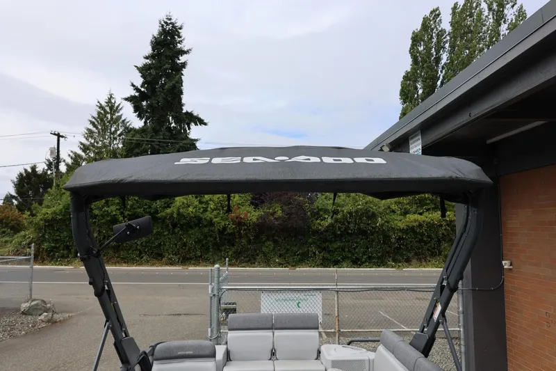 Slide: The Image of 2022 Sea-Doo Switch Cruise 21 with canopy, parked outdoors near greenery. - 33