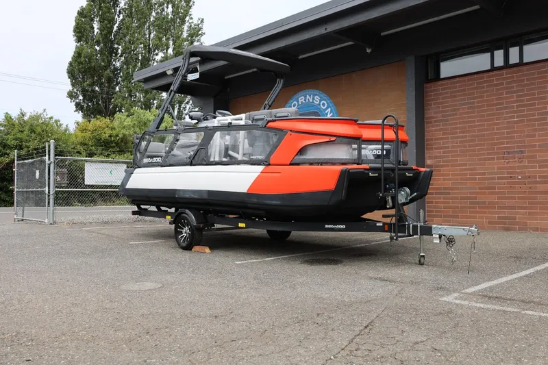 Slide: The Image of 2022 Sea-Doo Switch Cruise 21 on trailer, parked outdoors near a brick building. - 4