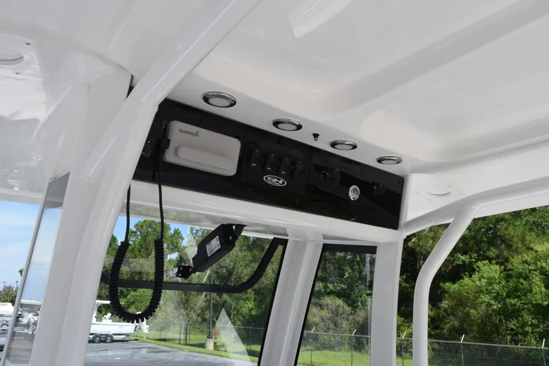 Slide: The Image of 2026 Sea Hunt Ultra 235 SE boat console with Garmin electronics and overhead storage. - 13