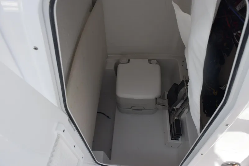 Slide: The Image of Interior of 2026 Sea Hunt Ultra 235 SE boat, featuring compact marine toilet. - 17