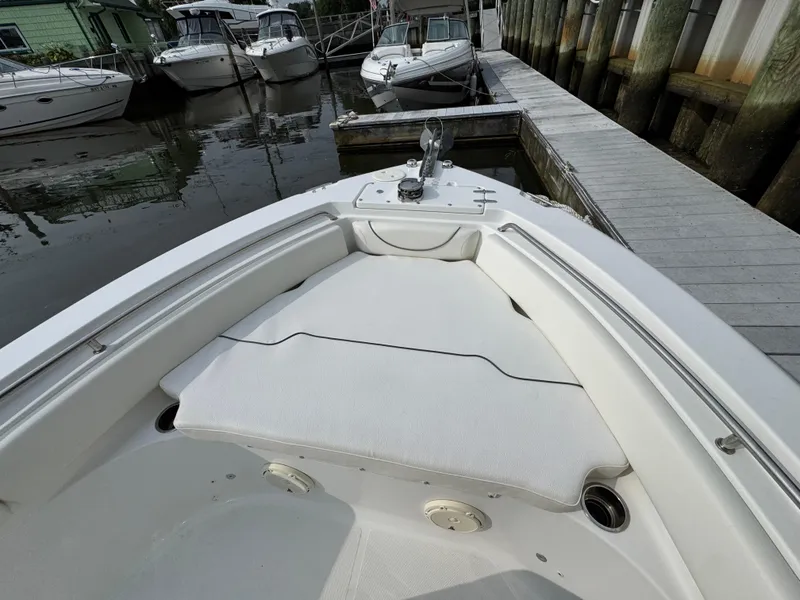 Slide: The Image of 2014 Sea Hunt Ultra 196 boat docked, featuring white seating and deck area. - 12
