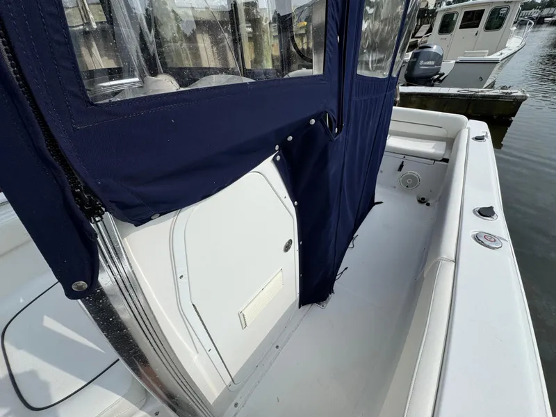 Slide: The Image of 2014 Sea Hunt Ultra 196 boat seat with blue canopy and white upholstery. - 14