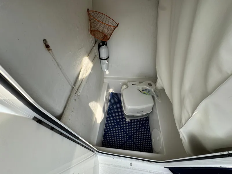 Slide: The Image of 2014 Sea Hunt Ultra 196 boat with blue canopy, docked near water. - 15