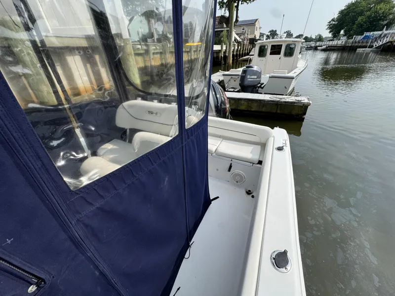 Slide: The Image of 2014 Sea Hunt Ultra 196 boat interior with blue canopy and seating area. - 17