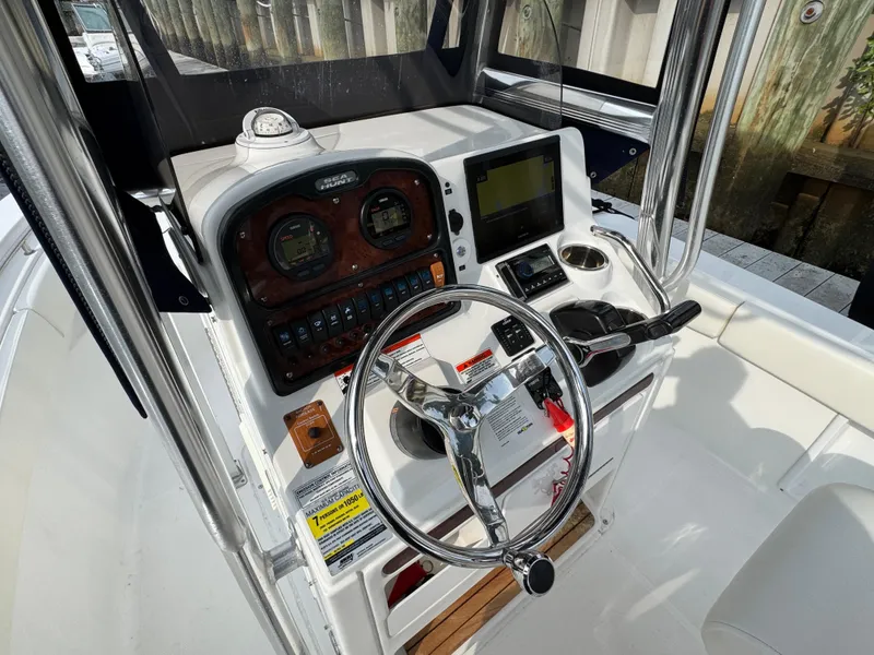 Slide: The Image of 2014 Sea Hunt Ultra 196 boat docked, featuring white seating and an outboard motor. - 19
