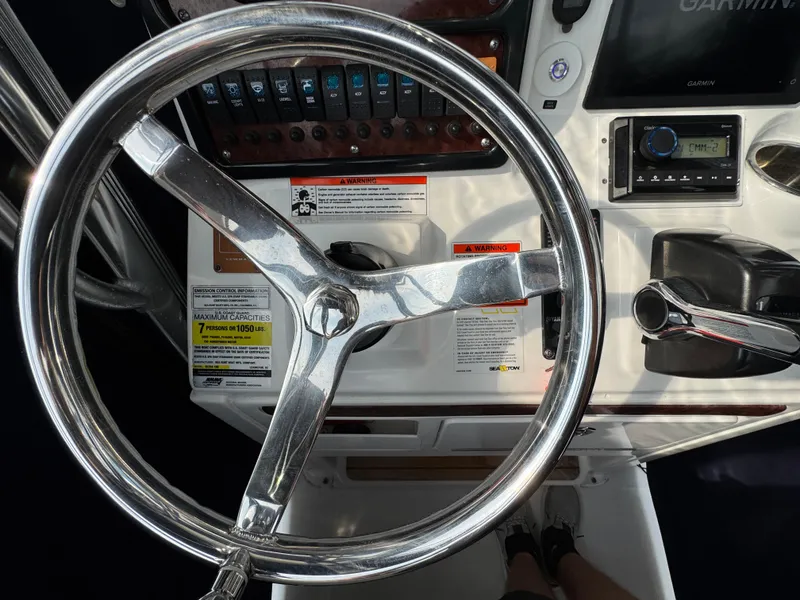 Slide: The Image of 2014 Sea Hunt Ultra 196 boat docked, view from helm, surrounded by other boats. - 7