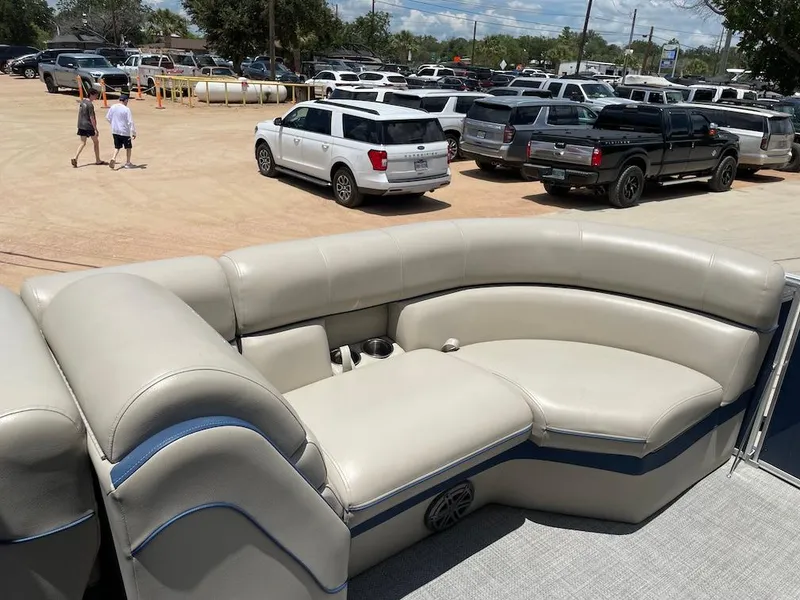 Slide: The Image of Pontoon boat interior with beige seating, South Bay 500 model, 2017, parked in a busy lot. - 11