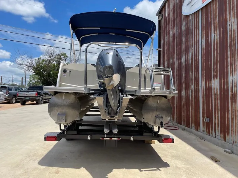 Slide: The Image of 2017 South Bay 500 pontoon boat with outboard motor, parked on a trailer. - 3