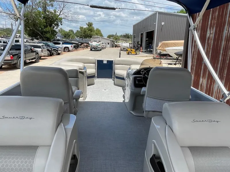 Slide: The Image of Interior view of a 2017 South Bay 500 pontoon boat at a marina. - 5