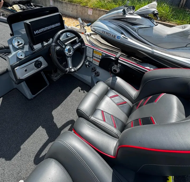 Slide: The Image of 2021 Tracker Nitro Z21 SC boat interior with steering wheel and seats. - 2
