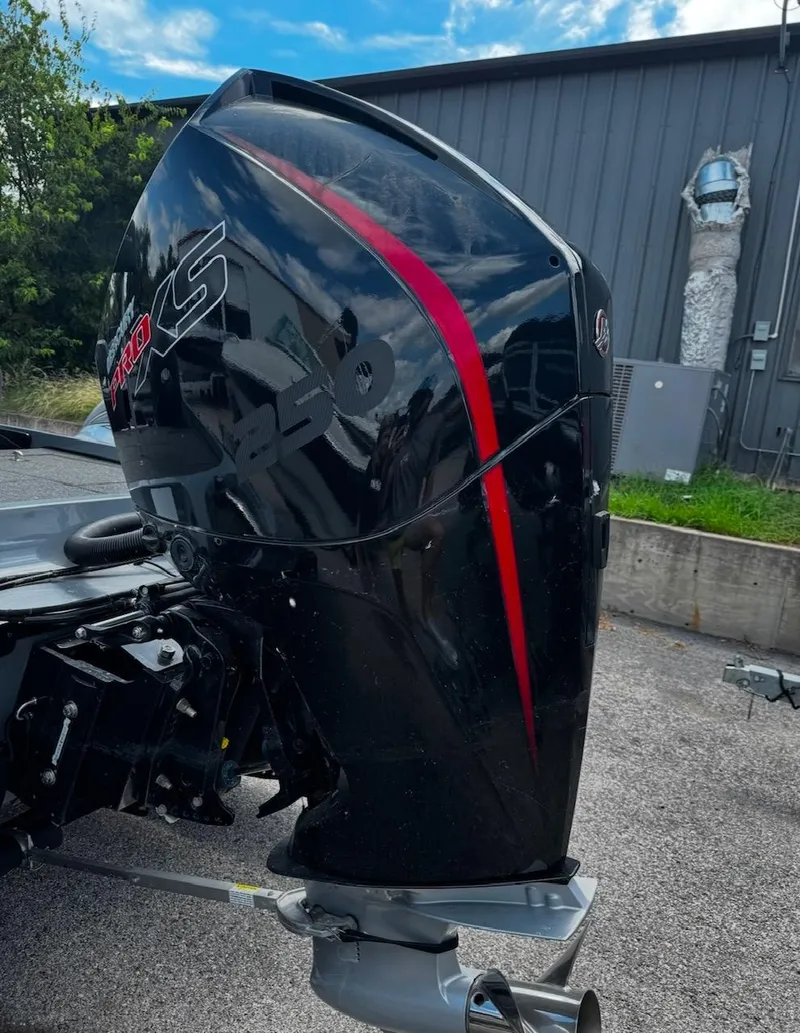 Slide: The Image of 2021 Tracker Nitro Z21 SC boat engine with red accents, parked outdoors. - 9