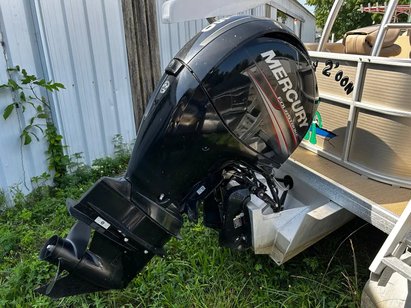 Slide: The Image of Outboard motor on 2015 Sweetwater Premium Edition 240 pontoon boat, parked on grass. - 11