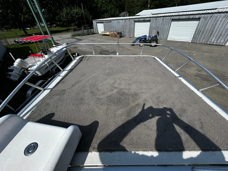 Slide: The Image of Top deck of a 2015 Sweetwater Premium Edition 240 boat, with surrounding marina view. - 3