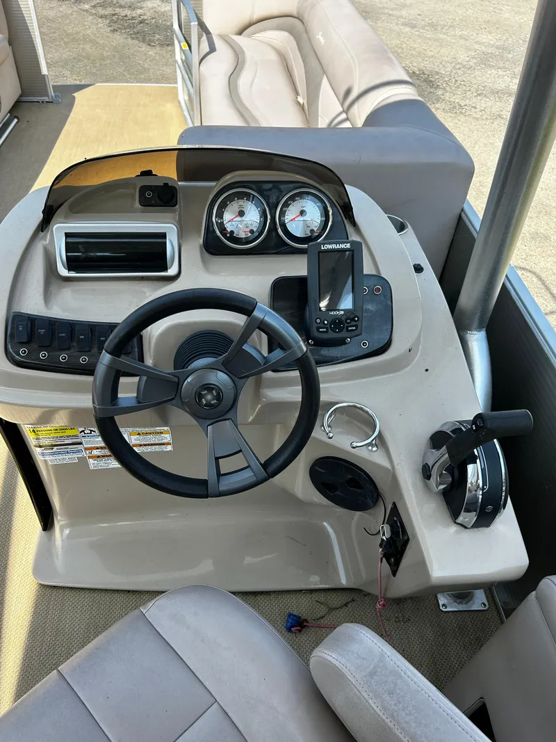 Slide: The Image of Steering console of 2015 Sweetwater Premium Edition 240 pontoon boat with gauges and controls. - 4