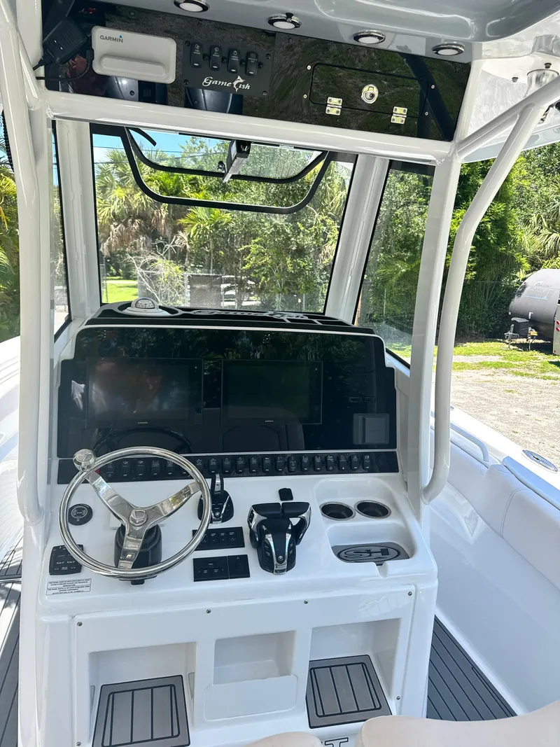 Slide: The Image of 2021 Sea Hunt Gamefish 30 Coffin Box boat console with steering wheel and controls. - 10