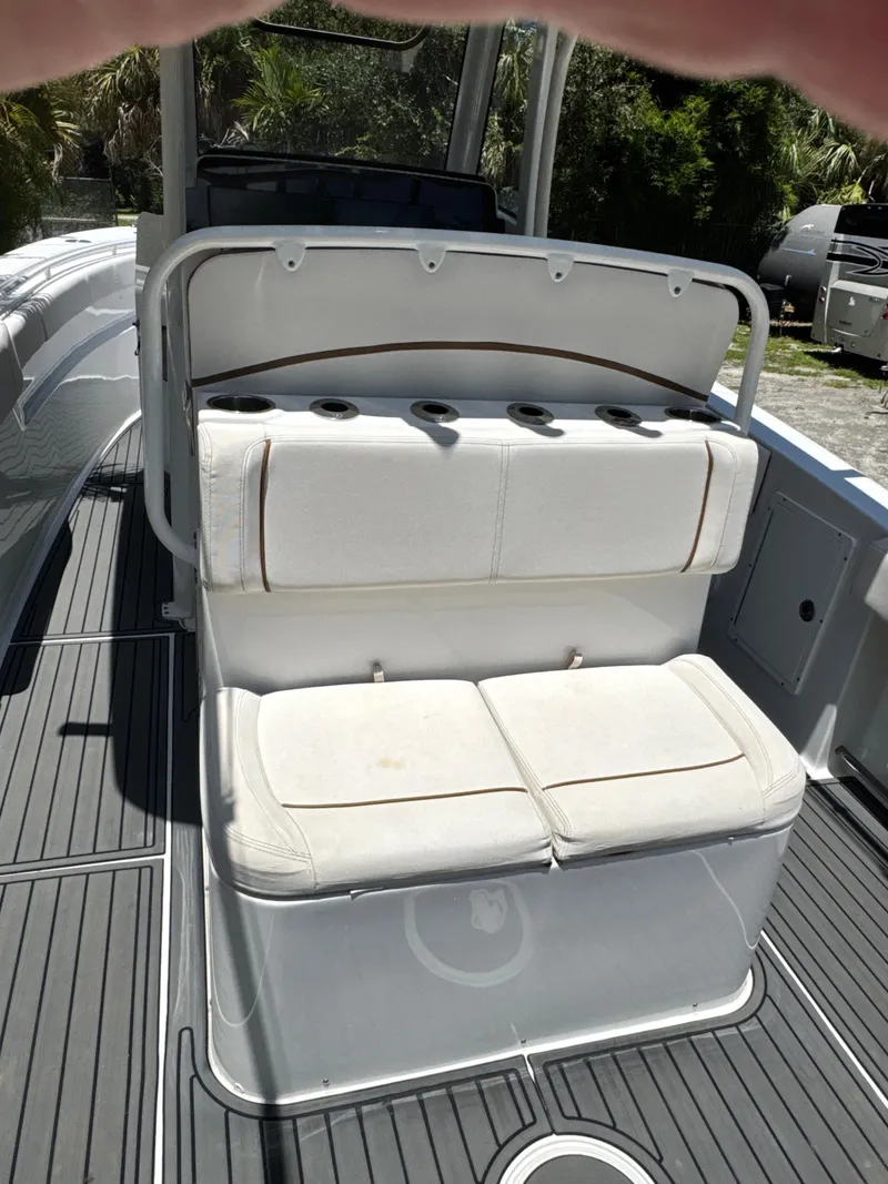 Slide: The Image of 2021 Sea Hunt Gamefish 30 Coffin Box boat interior with cushioned seating and rod holders. - 13