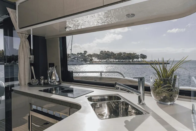 Slide: The Image of Modern kitchen interior on 2025 Cruisers Yachts 57 Fly, overlooking serene waterfront. - 26