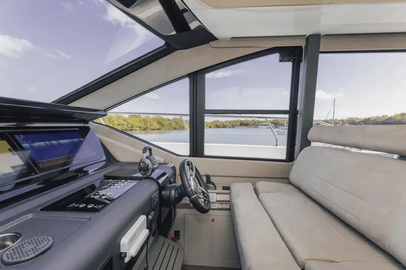 Slide: The Image of Interior view of 2025 Cruisers Yachts 57 Fly, featuring helm and seating area. - 36