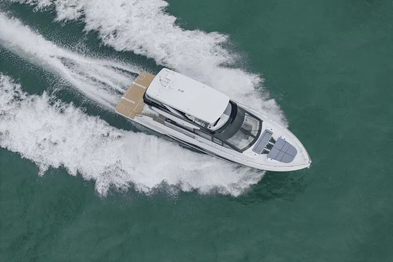 Slide: The Image of 2025 Cruisers Yachts 57 Fly cruising on open water, aerial view. - 1