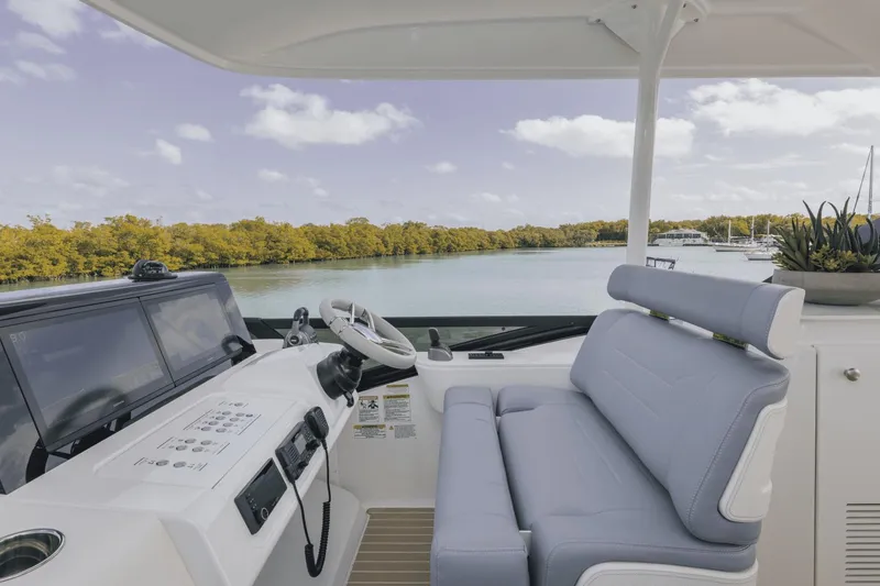 Slide: The Image of 2025 Cruisers Yachts 57 Fly helm with dual screens and plush seating. - 18