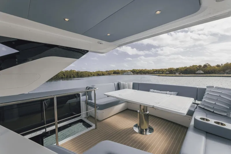 Slide: The Image of Luxurious 2025 Cruisers Yachts 57 Fly with elegant outdoor seating and scenic water view. - 21