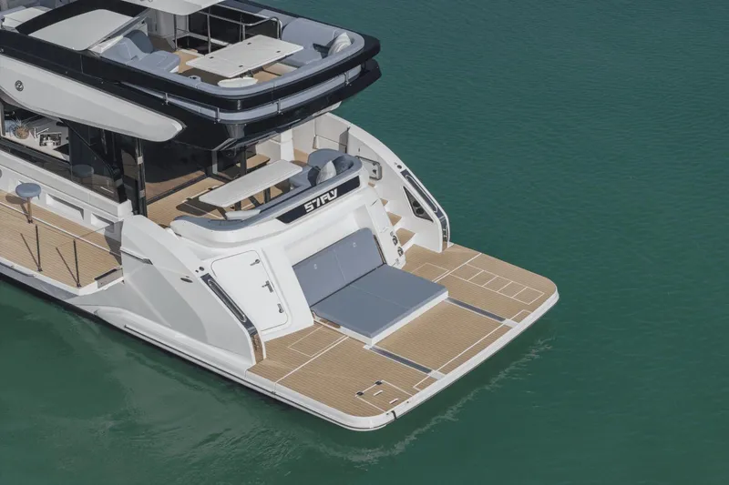 Slide: The Image of 2025 Cruisers Yachts 57 Fly luxury yacht on calm water, rear view. - 9